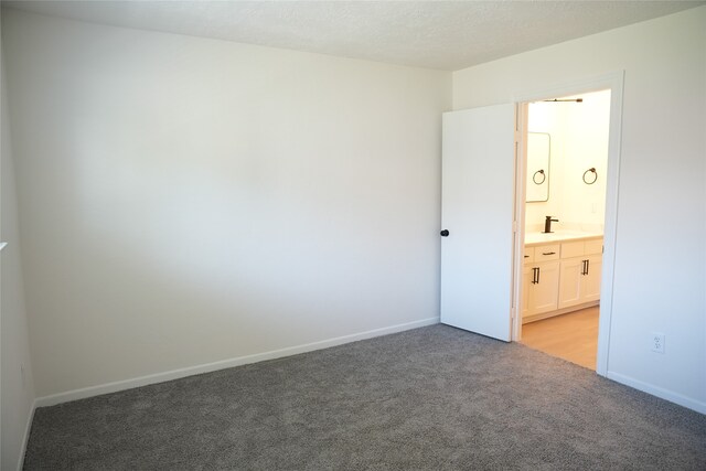 carpeted spare room featuring a textured ceiling