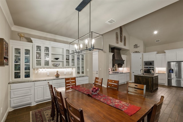 dining space featuring dark wood-type flooring, a chandelier, visible vents, and baseboards