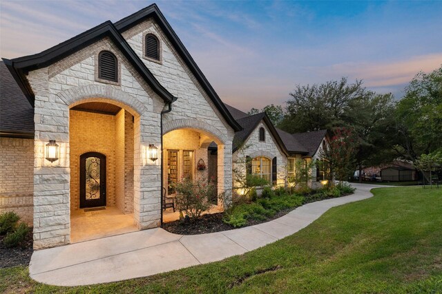 french provincial home featuring a front yard