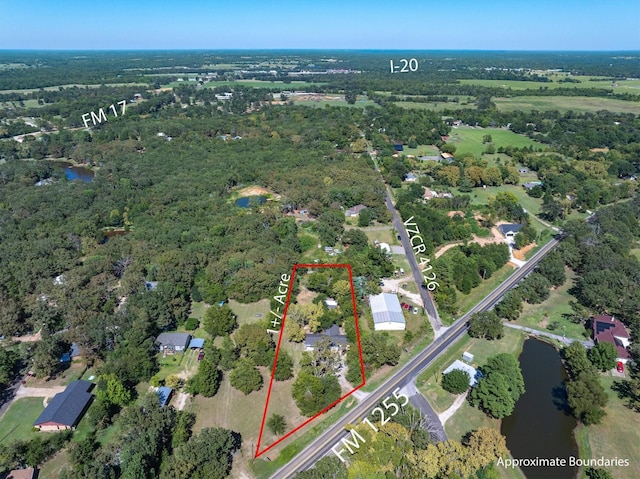 birds eye view of property with a view of trees and a water view