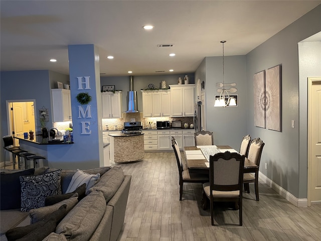 dining space featuring light hardwood / wood-style flooring and a notable chandelier