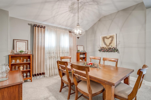 carpeted dining space featuring vaulted ceiling and a chandelier