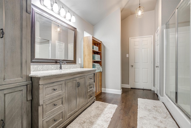 bathroom featuring a shower with shower door, wood-type flooring, and vanity