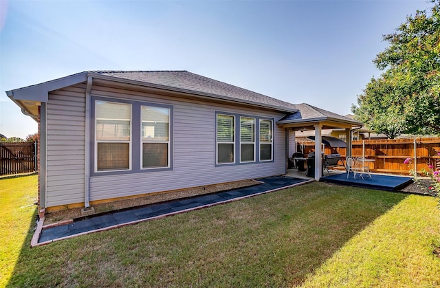 rear view of property with a lawn and a patio