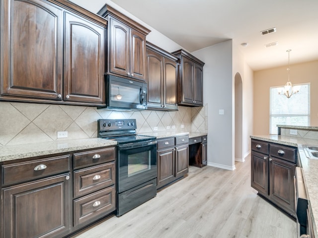 kitchen featuring backsplash, an inviting chandelier, light hardwood / wood-style floors, black appliances, and dark brown cabinetry