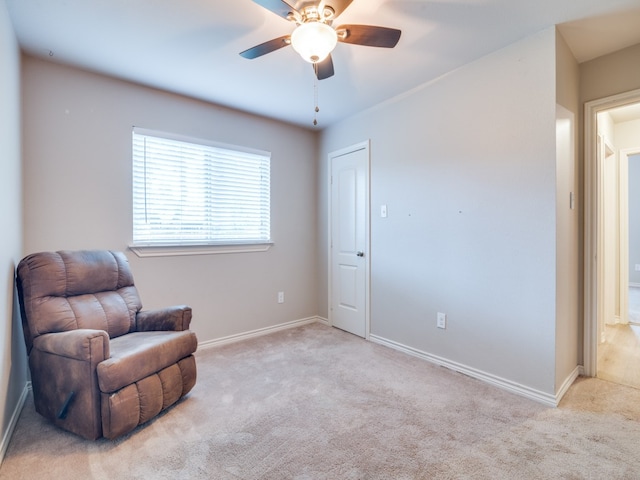 living area featuring ceiling fan and light colored carpet