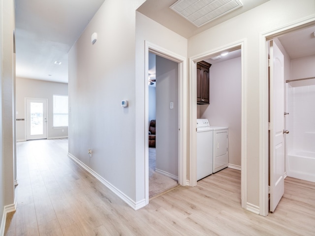 hall with light hardwood / wood-style flooring and washer and clothes dryer