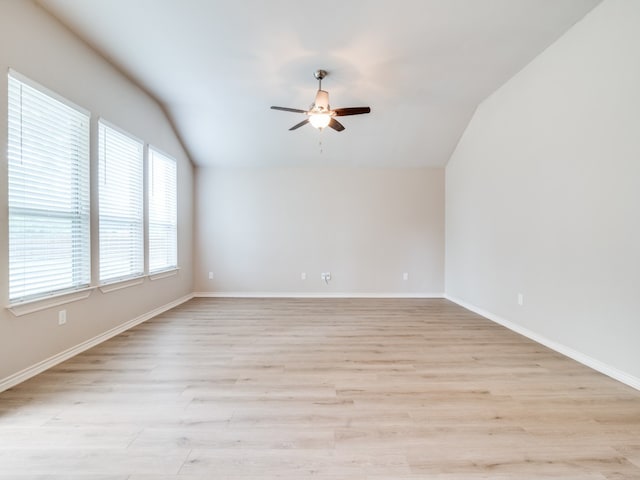 spare room featuring light hardwood / wood-style flooring, ceiling fan, and vaulted ceiling