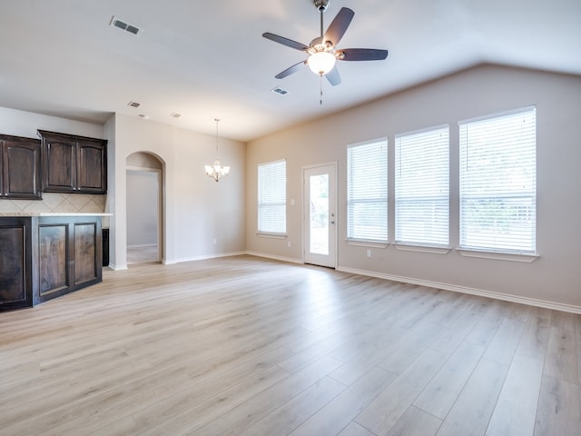 unfurnished living room featuring ceiling fan with notable chandelier, lofted ceiling, and light hardwood / wood-style flooring