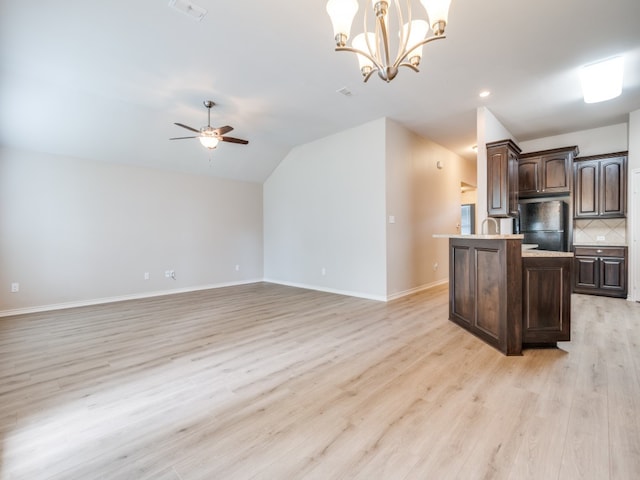 kitchen featuring ceiling fan with notable chandelier, dark brown cabinets, black refrigerator, hanging light fixtures, and light hardwood / wood-style floors