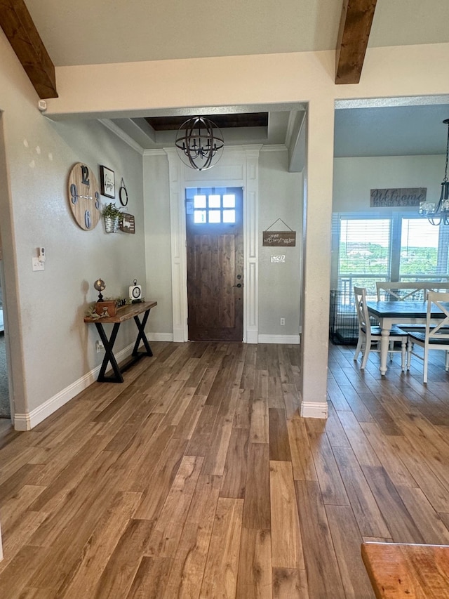 entrance foyer with plenty of natural light, a chandelier, hardwood / wood-style flooring, and beam ceiling