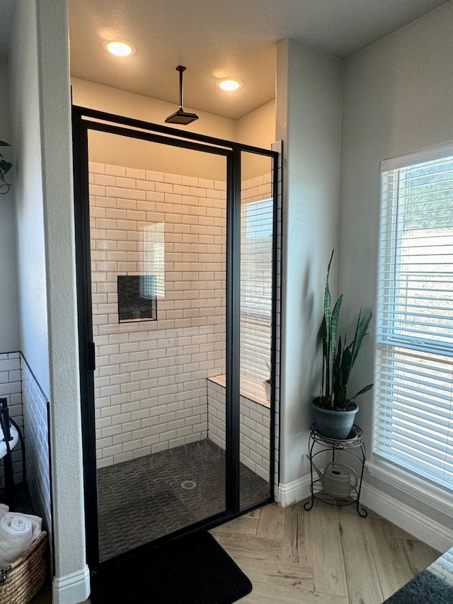 bathroom featuring hardwood / wood-style floors and a tile shower