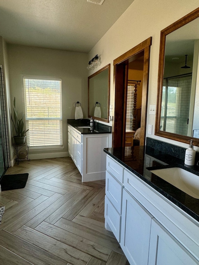 bathroom featuring parquet floors, vanity, a shower, and a textured ceiling