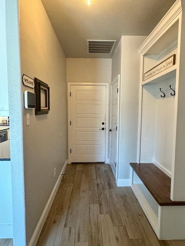 mudroom featuring a textured ceiling and hardwood / wood-style flooring