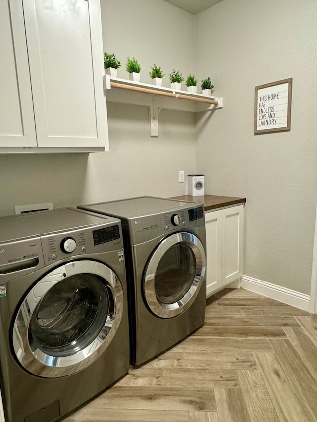 laundry room with washing machine and dryer and cabinets