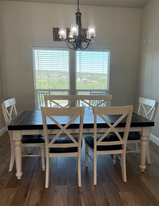 dining space featuring dark hardwood / wood-style flooring, a healthy amount of sunlight, and an inviting chandelier