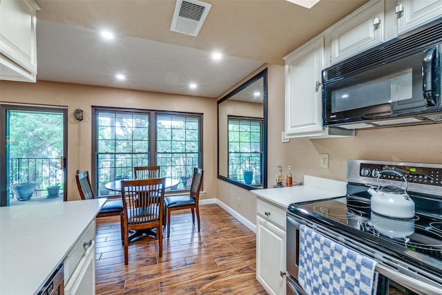 kitchen with stainless steel range with electric cooktop, white cabinets, light wood-type flooring, and a healthy amount of sunlight