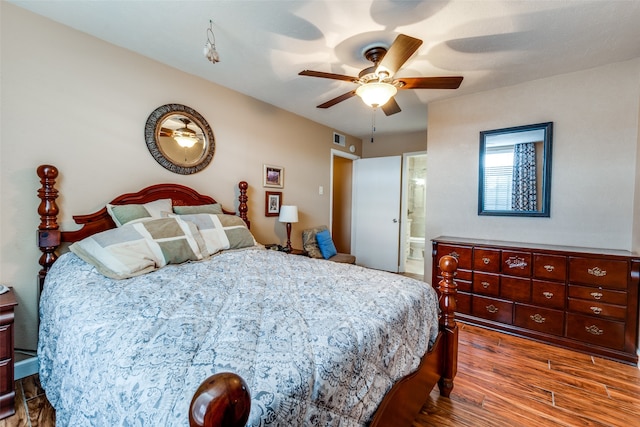 bedroom featuring ceiling fan, connected bathroom, and dark hardwood / wood-style floors