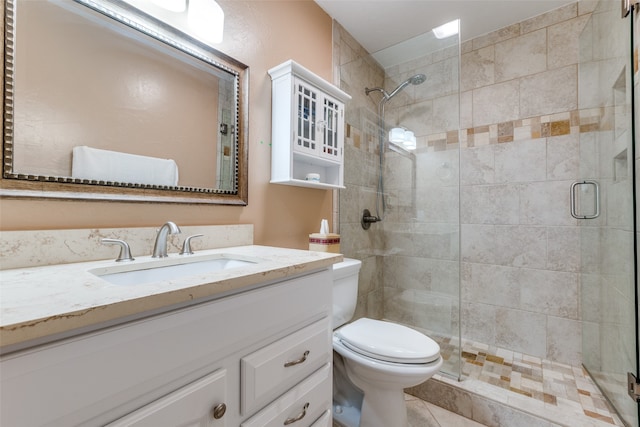 bathroom featuring tile patterned flooring, vanity, toilet, and a shower with shower door