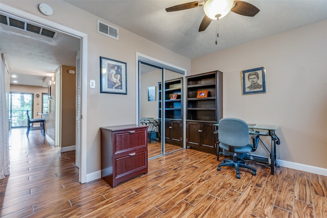 home office featuring ceiling fan, a textured ceiling, and light hardwood / wood-style flooring