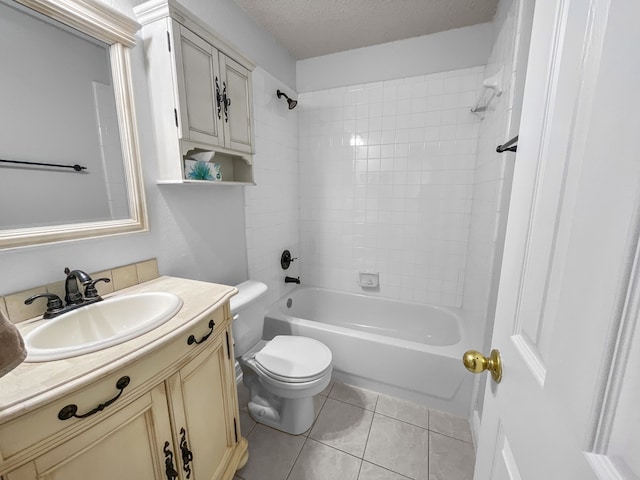 full bathroom featuring tile patterned flooring, toilet, tiled shower / bath combo, vanity, and a textured ceiling