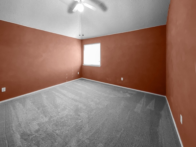 empty room with ceiling fan, carpet floors, and a textured ceiling