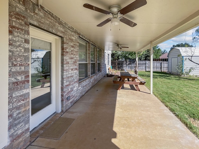 view of patio with ceiling fan and a storage shed