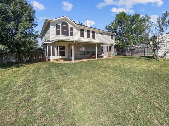 rear view of property with a yard and a patio area