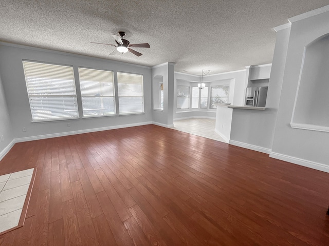 unfurnished living room with ceiling fan, hardwood / wood-style flooring, crown molding, and a textured ceiling