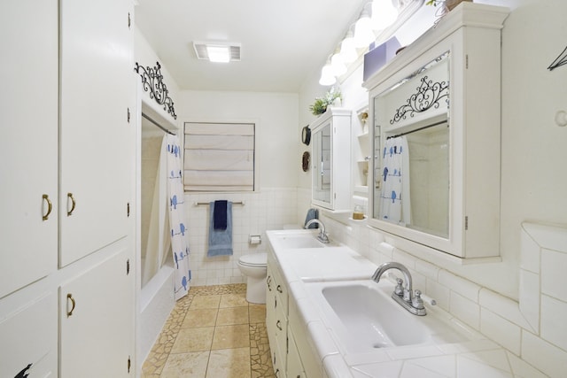 full bathroom featuring toilet, vanity, tile walls, tile patterned flooring, and shower / bath combo with shower curtain