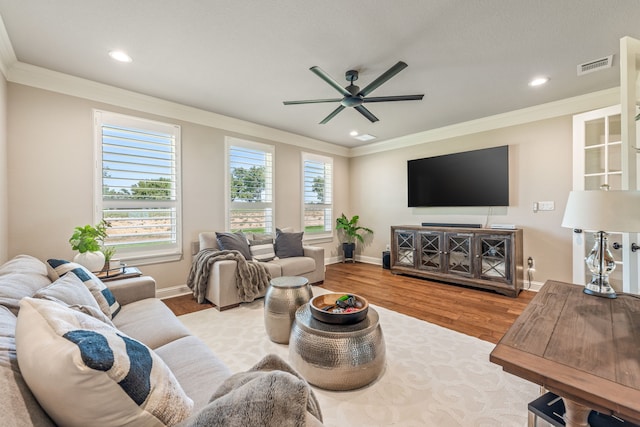 living room featuring crown molding, ceiling fan, and light hardwood / wood-style floors