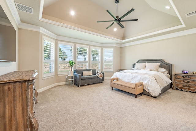 bedroom featuring light carpet, a tray ceiling, crown molding, and ceiling fan