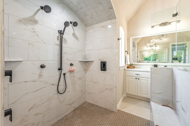 bathroom with vanity, vaulted ceiling, tile patterned floors, and a tile shower