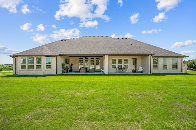 rear view of property with a lawn and a patio area