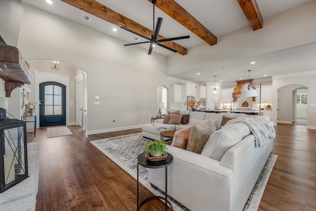 living room featuring ceiling fan, dark hardwood / wood-style floors, and beam ceiling