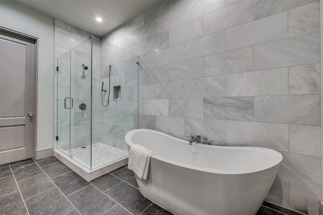 bathroom with separate shower and tub, tile walls, and tile patterned flooring