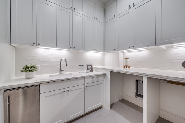 laundry area with light tile patterned floors and sink