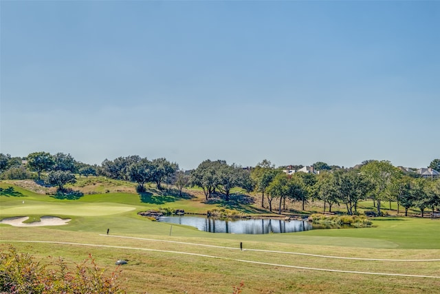 view of property's community with a lawn and a water view