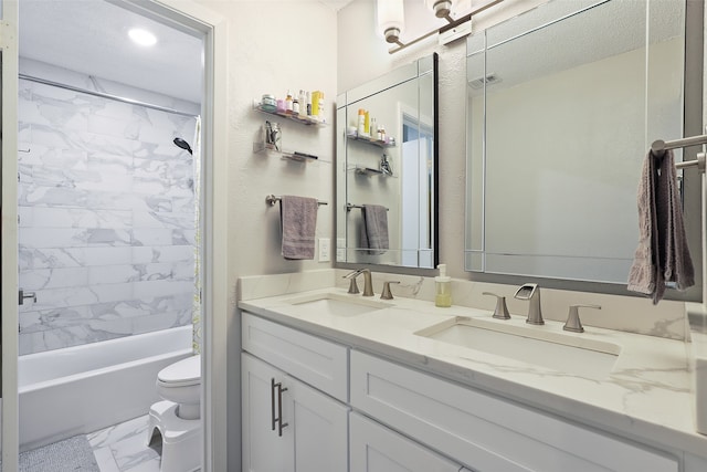 full bathroom with vanity, tiled shower / bath, and toilet