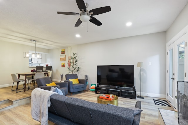 living room with light hardwood / wood-style floors and ceiling fan