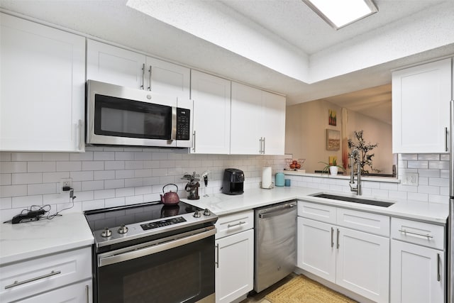 kitchen featuring white cabinetry, appliances with stainless steel finishes, tasteful backsplash, and sink