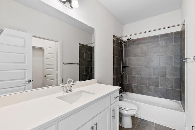 full bathroom with tile patterned flooring, tiled shower / bath, toilet, and vanity