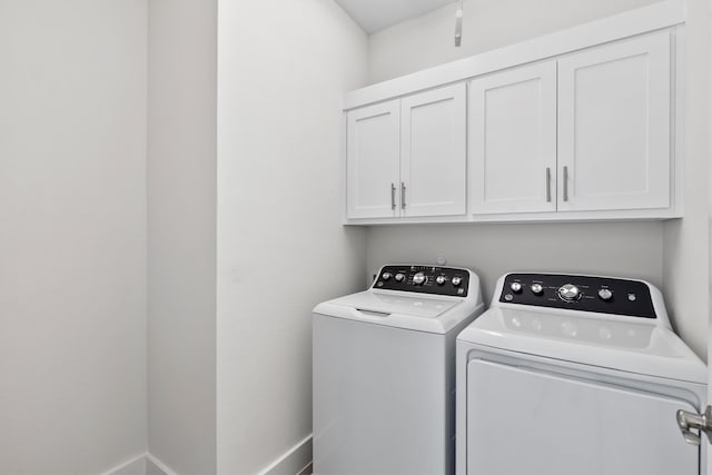 laundry room featuring cabinets and washing machine and clothes dryer