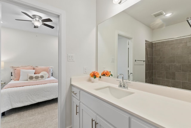 bathroom featuring ceiling fan, a tile shower, and vanity