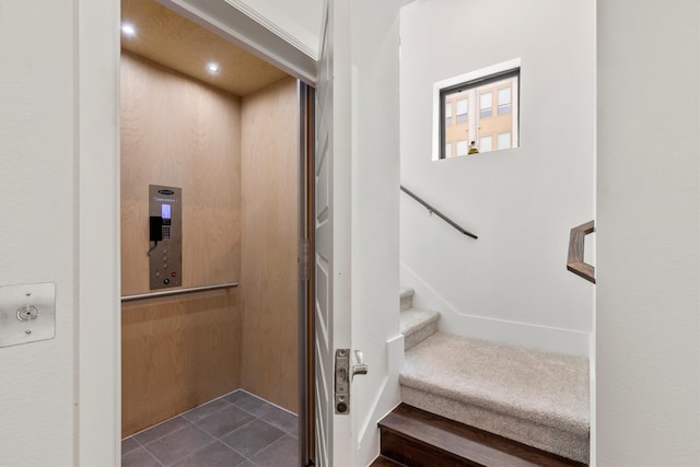 stairs with tile patterned flooring and elevator