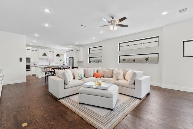 living room with ceiling fan and dark hardwood / wood-style floors