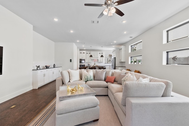 living room featuring hardwood / wood-style floors and ceiling fan