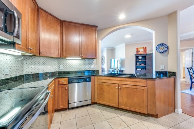 kitchen featuring tasteful backsplash, dark stone counters, stainless steel appliances, sink, and light tile patterned flooring