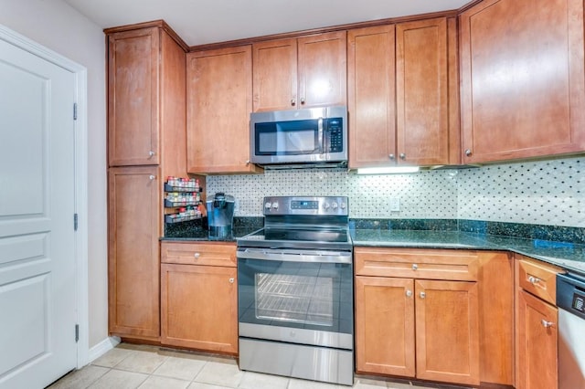 kitchen with backsplash, dark stone countertops, light tile patterned floors, and stainless steel appliances