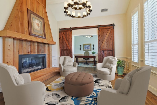 living room featuring a wealth of natural light, an inviting chandelier, and vaulted ceiling